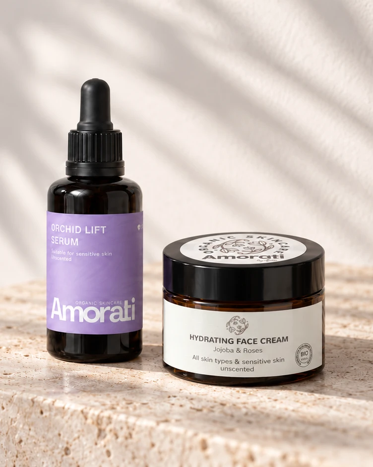 Orchid Lift Serum en Hydraterende Dagcrème op een travertijn blok voor een lichte muur met bladschaduwen.